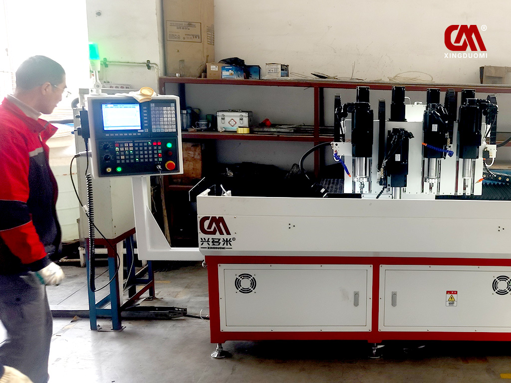 Workers are learning how to operate the DUOMI CNC four-spindle thermal drilling and tapping machine