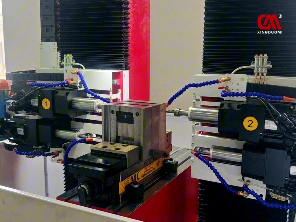 The four-spindle horizontal CNC drilling and tapping machine is simultaneously machining three metal products